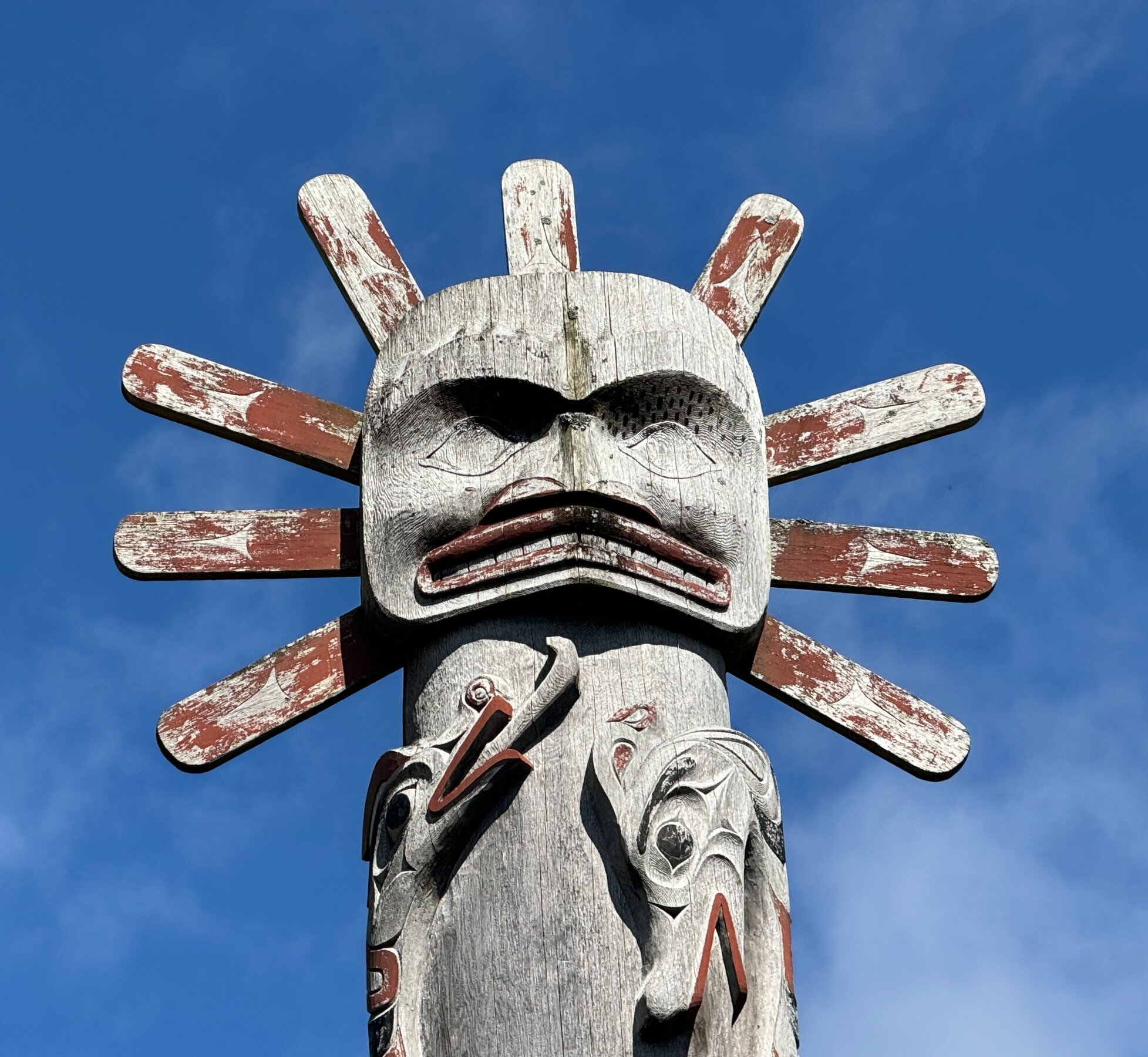 Top of a totem pole against the blue sky
