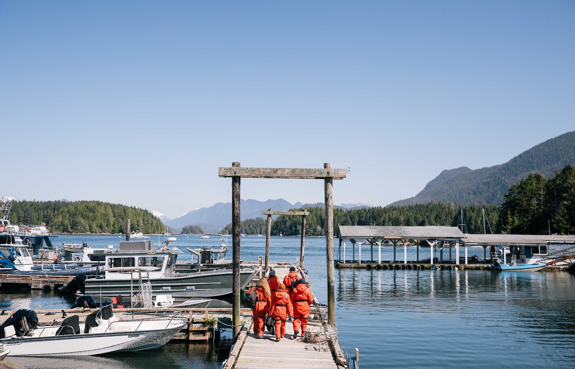 People in red floater suits walking down a dock
