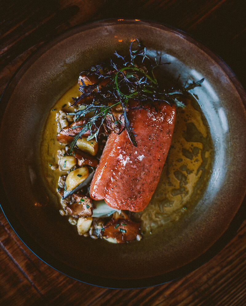 Elegantly plated meal of salmon  ona wooden table