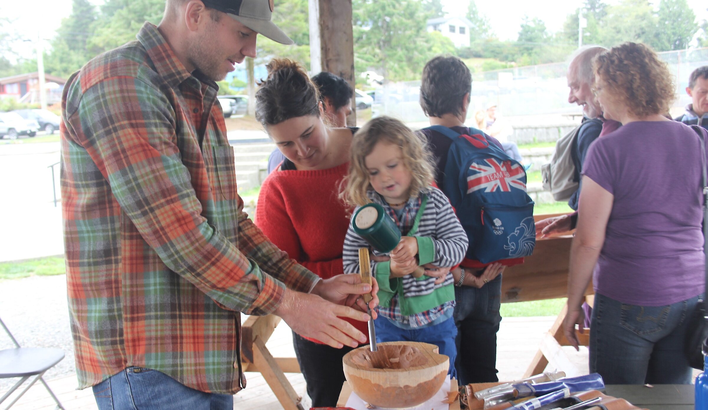 Wood carving artist teaching small child to carve