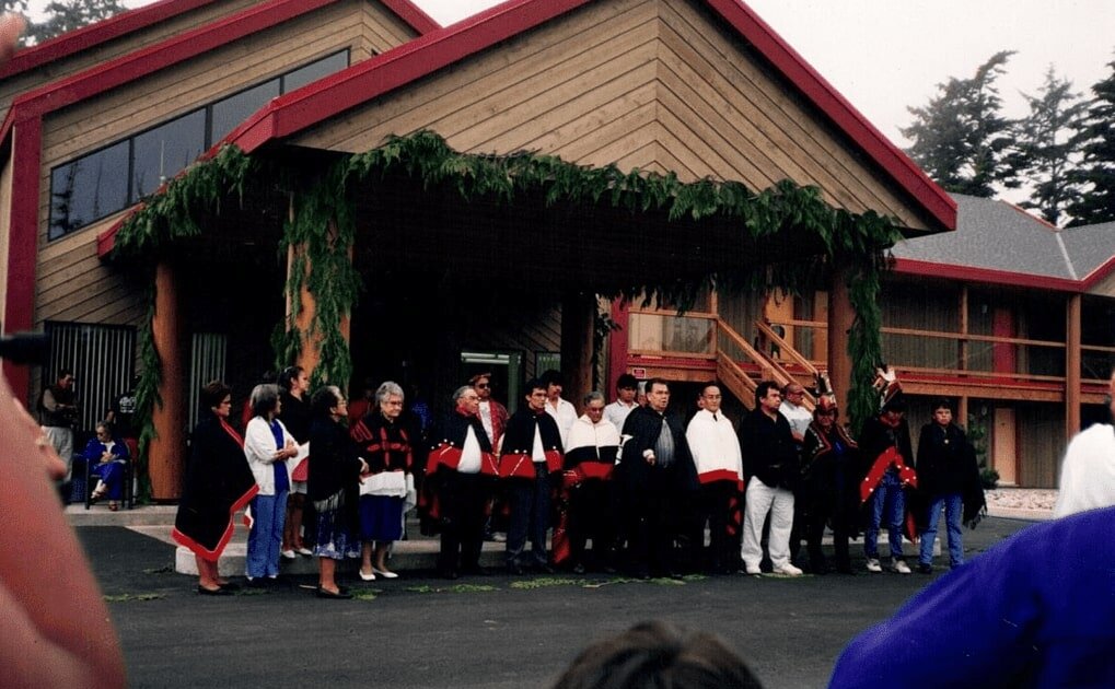 Tla-o-qui-aht men and women in red and black traditional dress at the opening of the Tin Wis Resort in 1993.