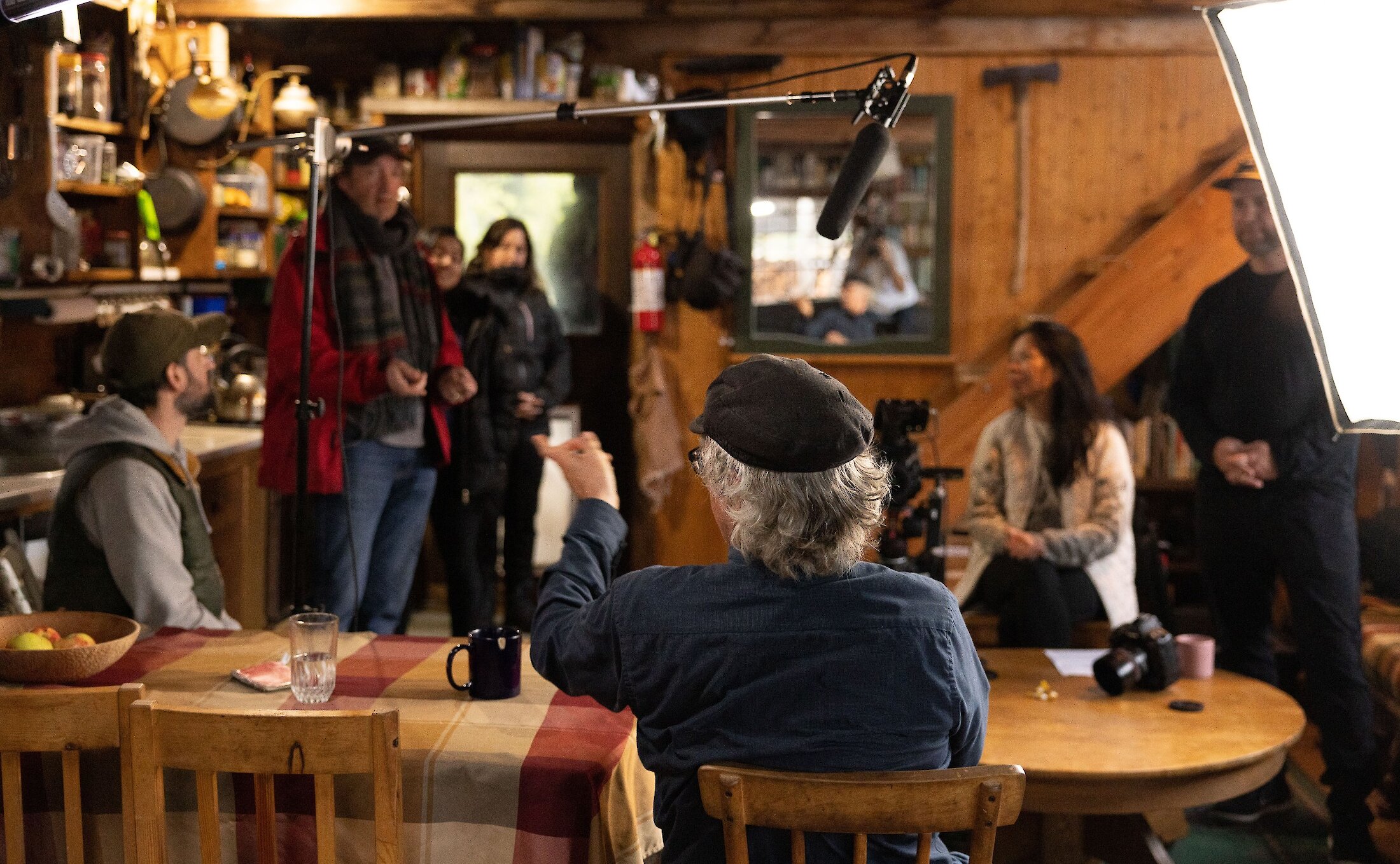 Camera crew filming a scene in a cabin.