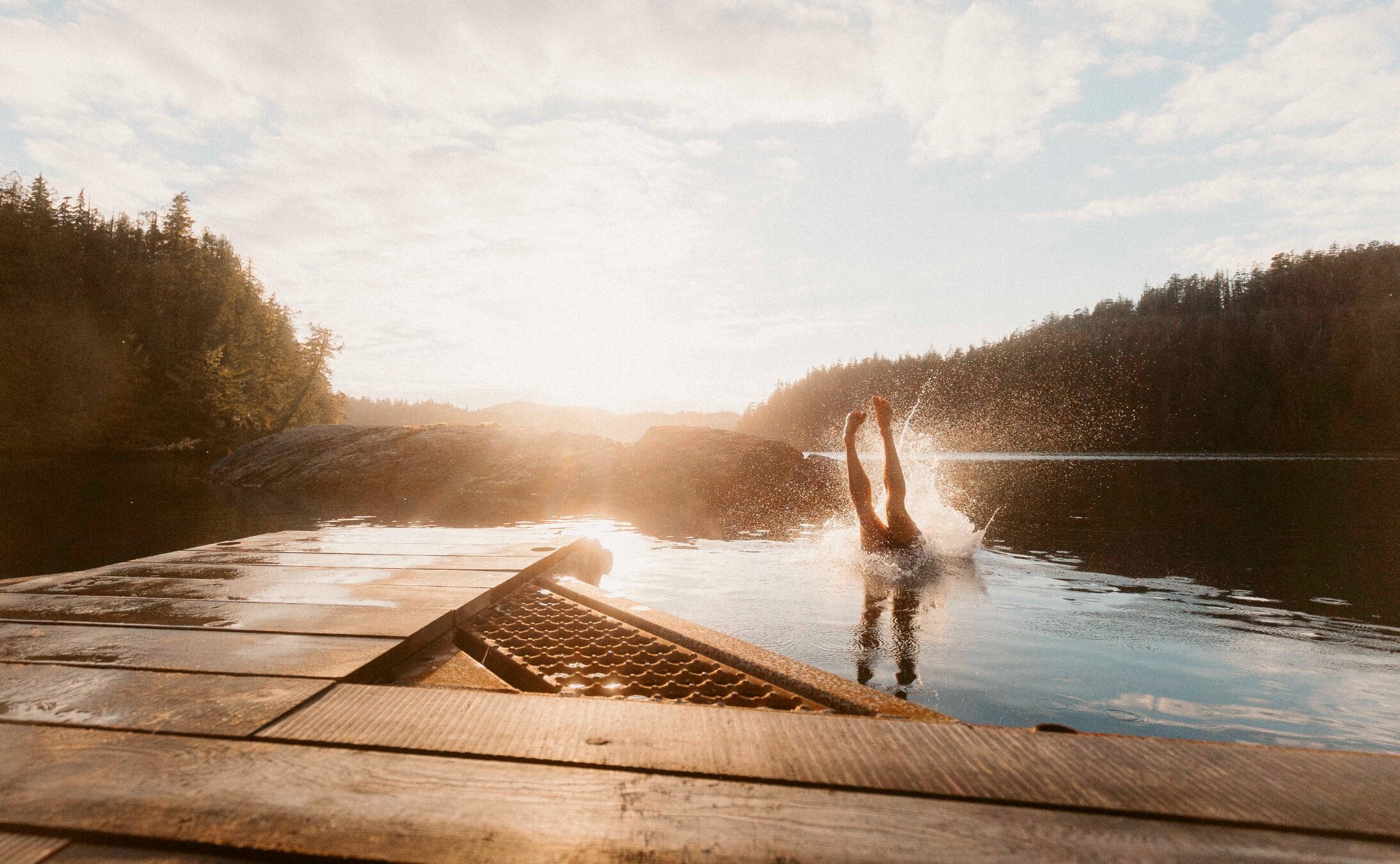 Diving off a dock into the ocean at Tofino Boating Co floating sauna