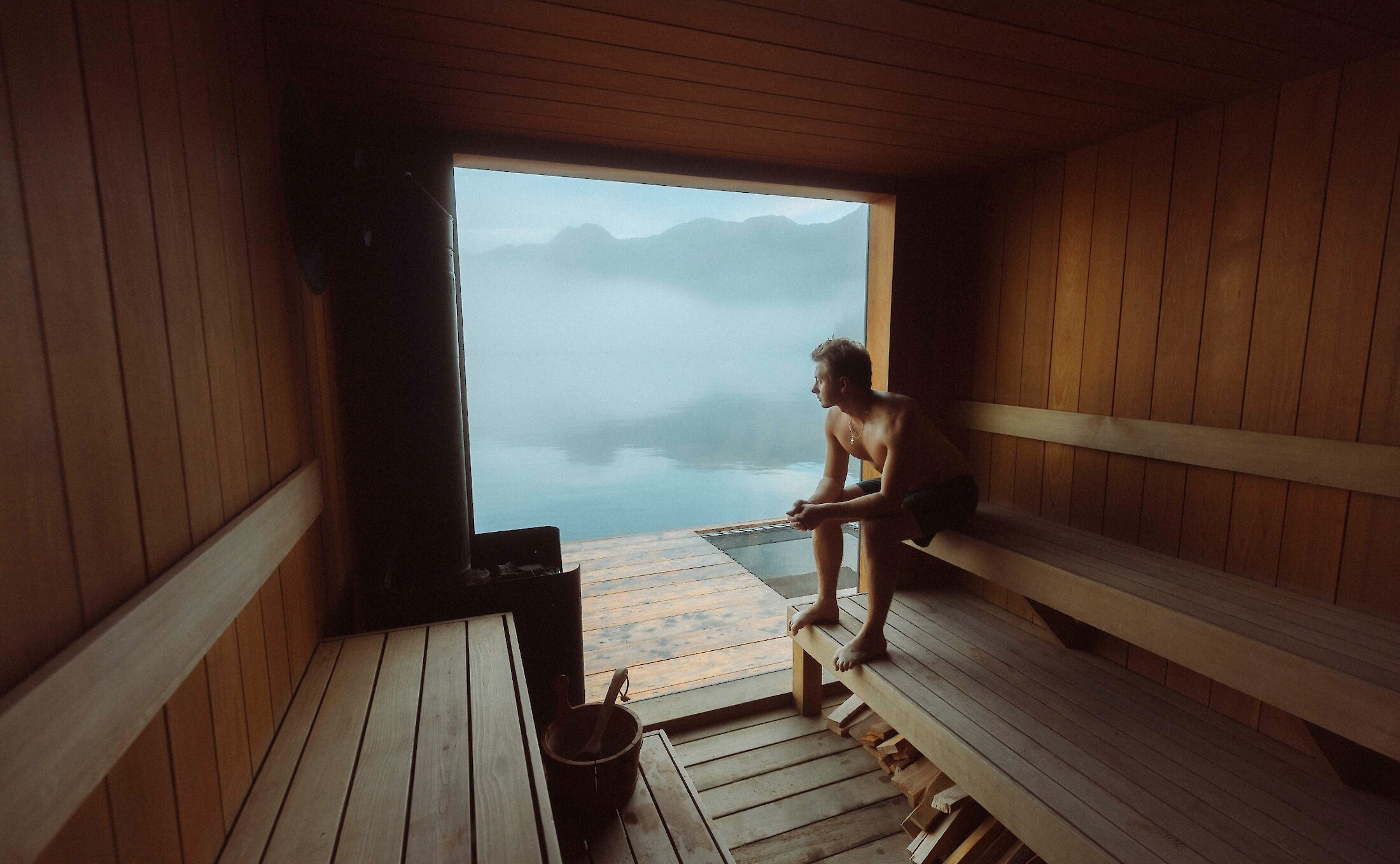 Person looking at the view from within a floating sauna