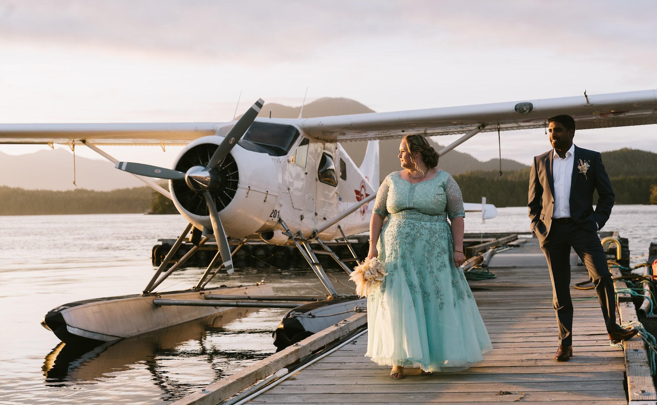 Bride in aqua dress with groom on seaplane dock