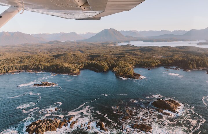 Aerial view of the islands of Clayoquot Sound and the wing of a plane taken through the window.