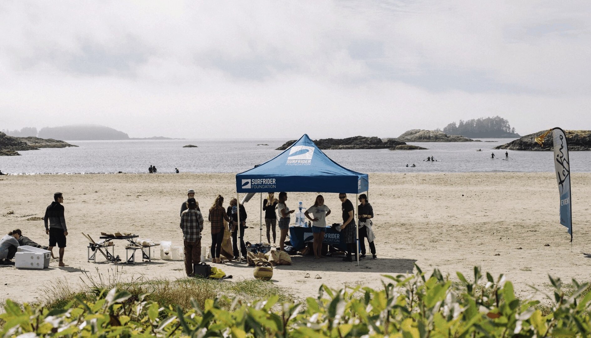 people at a beach cleanup with tent