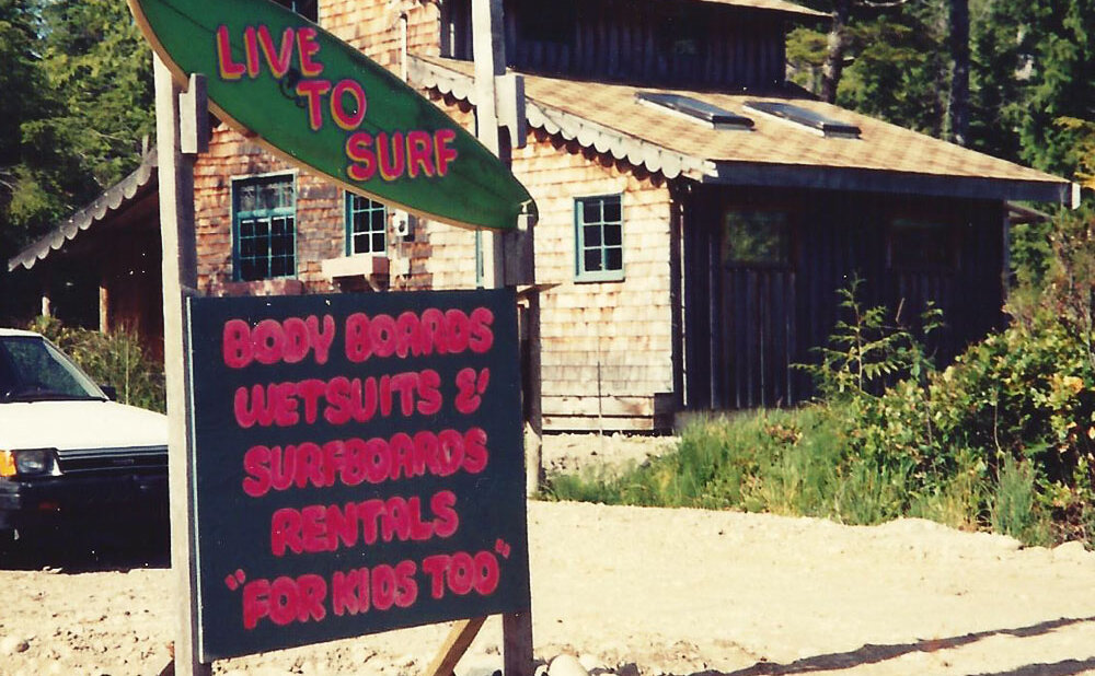 The original Live To Surf board shop sign along highway 4 with the store in the background (now where Chocolate Tofino & Tofitian operate).