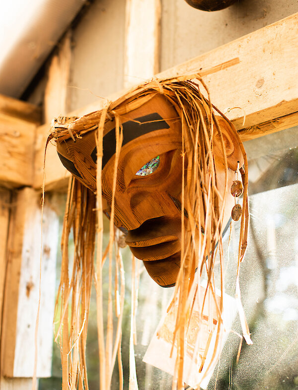 First Nations mask hanging in a workshop
