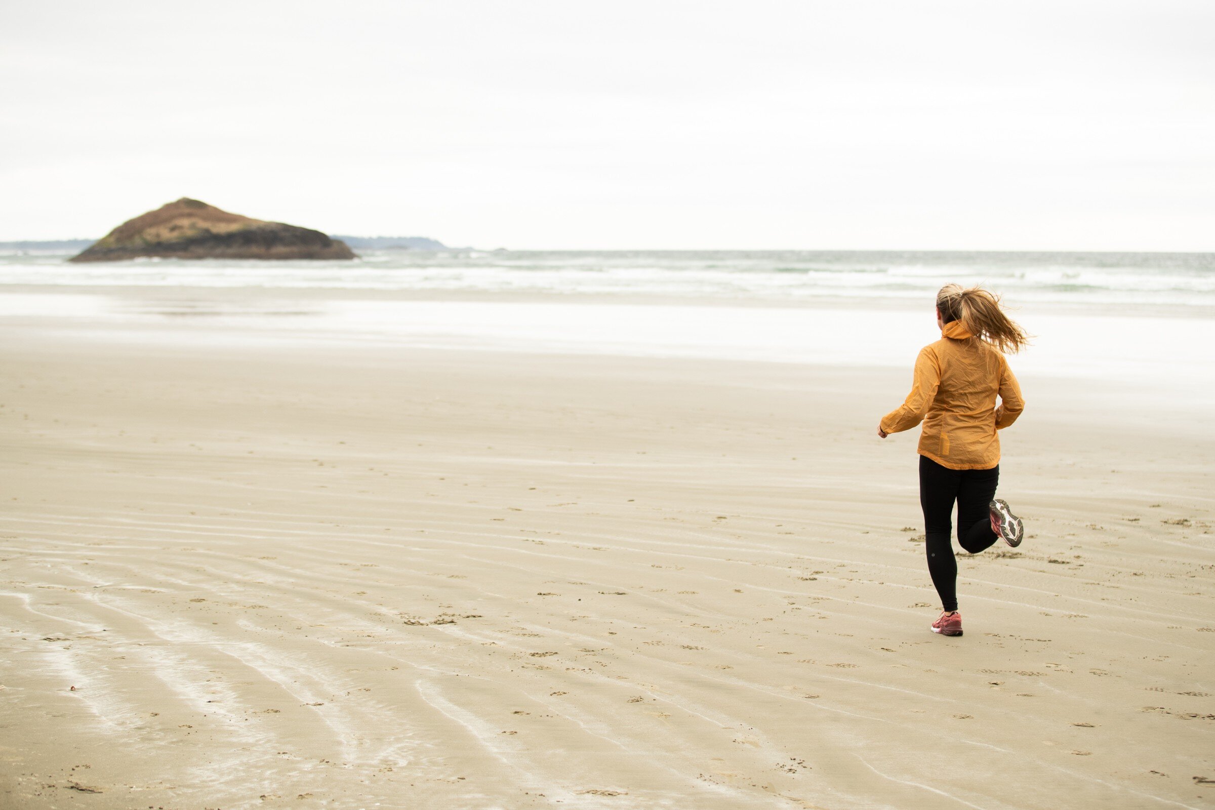 Person jogging on the sand on a cloudy day