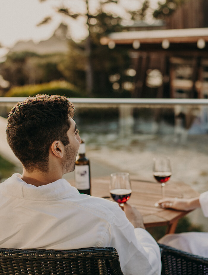 People sitting on their balcony drinking wine and looking at the view