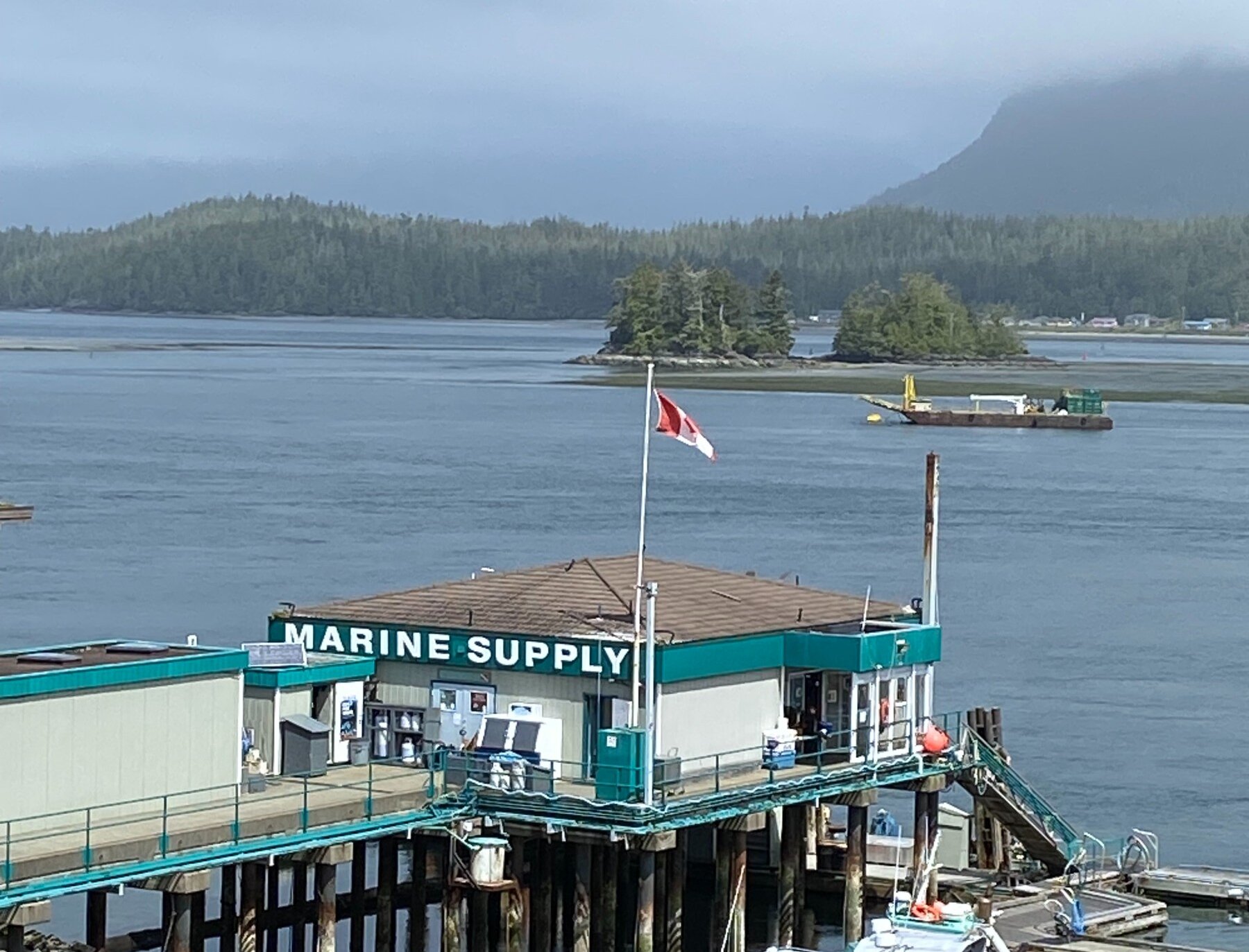 Marine supply store on a dock with Canada flag and islands in the background