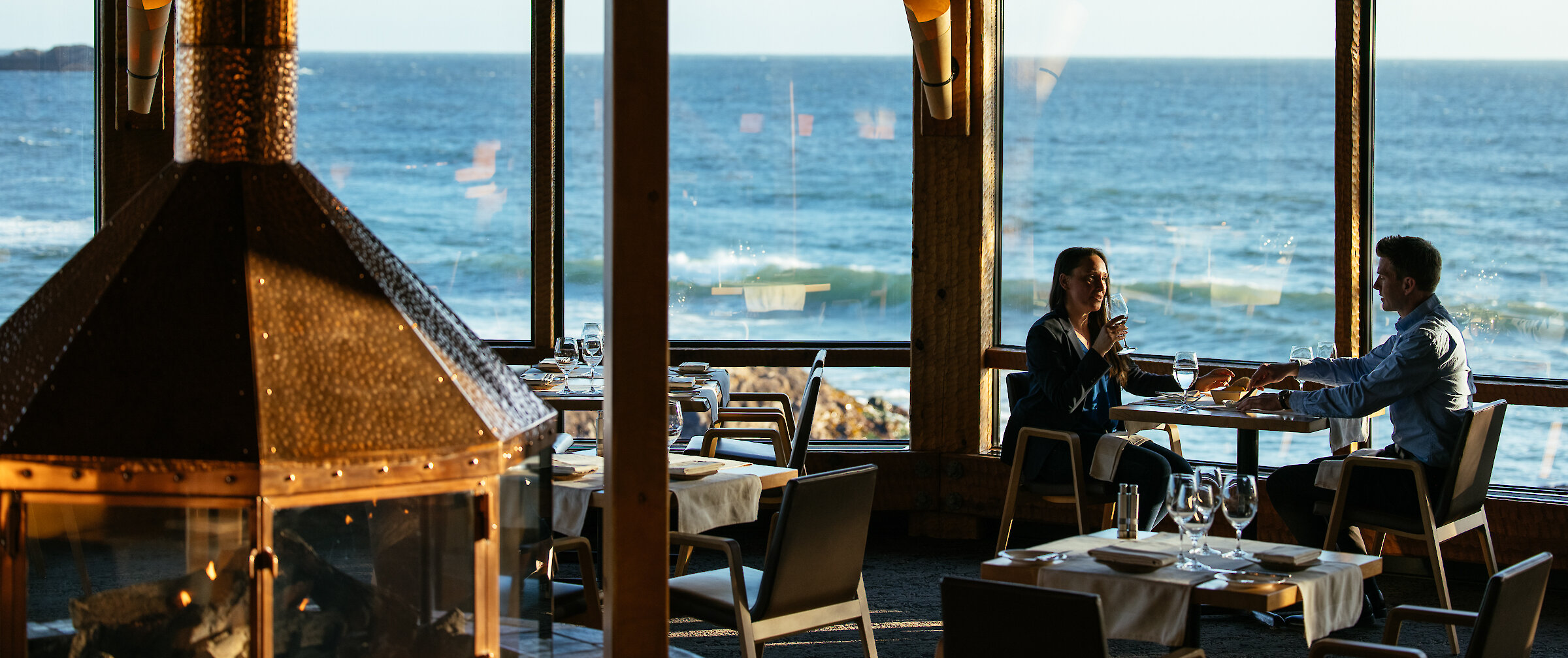 People dining at a table overlooking the sea