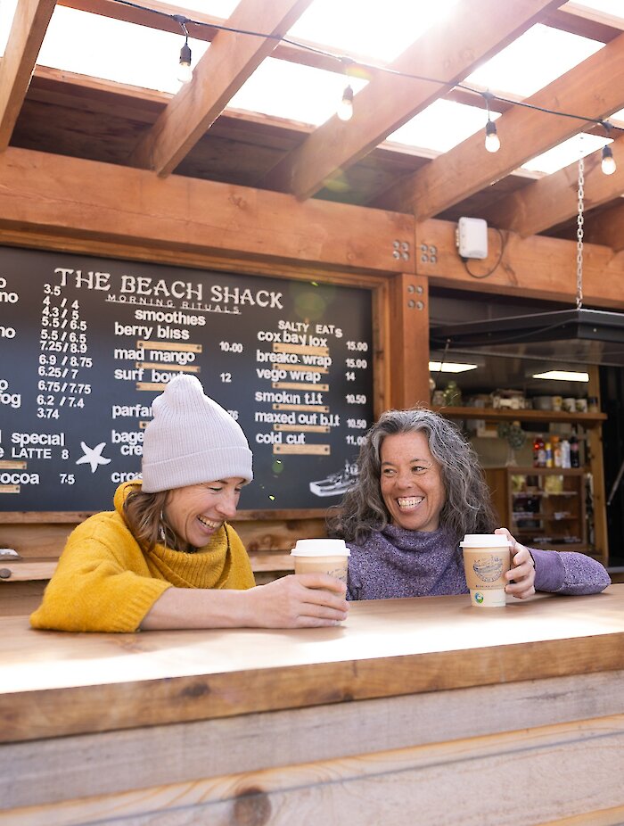 People enjoying a coffee at an outdoor beach shack