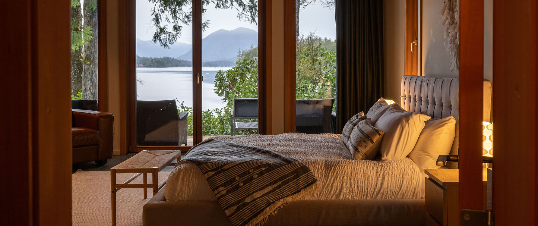 A bed overlooking the Tofino Inlet with mountains in the background