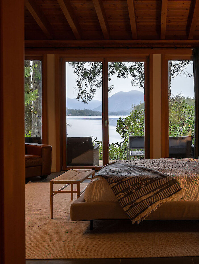 A bed overlooking the Tofino Inlet with mountains in the background