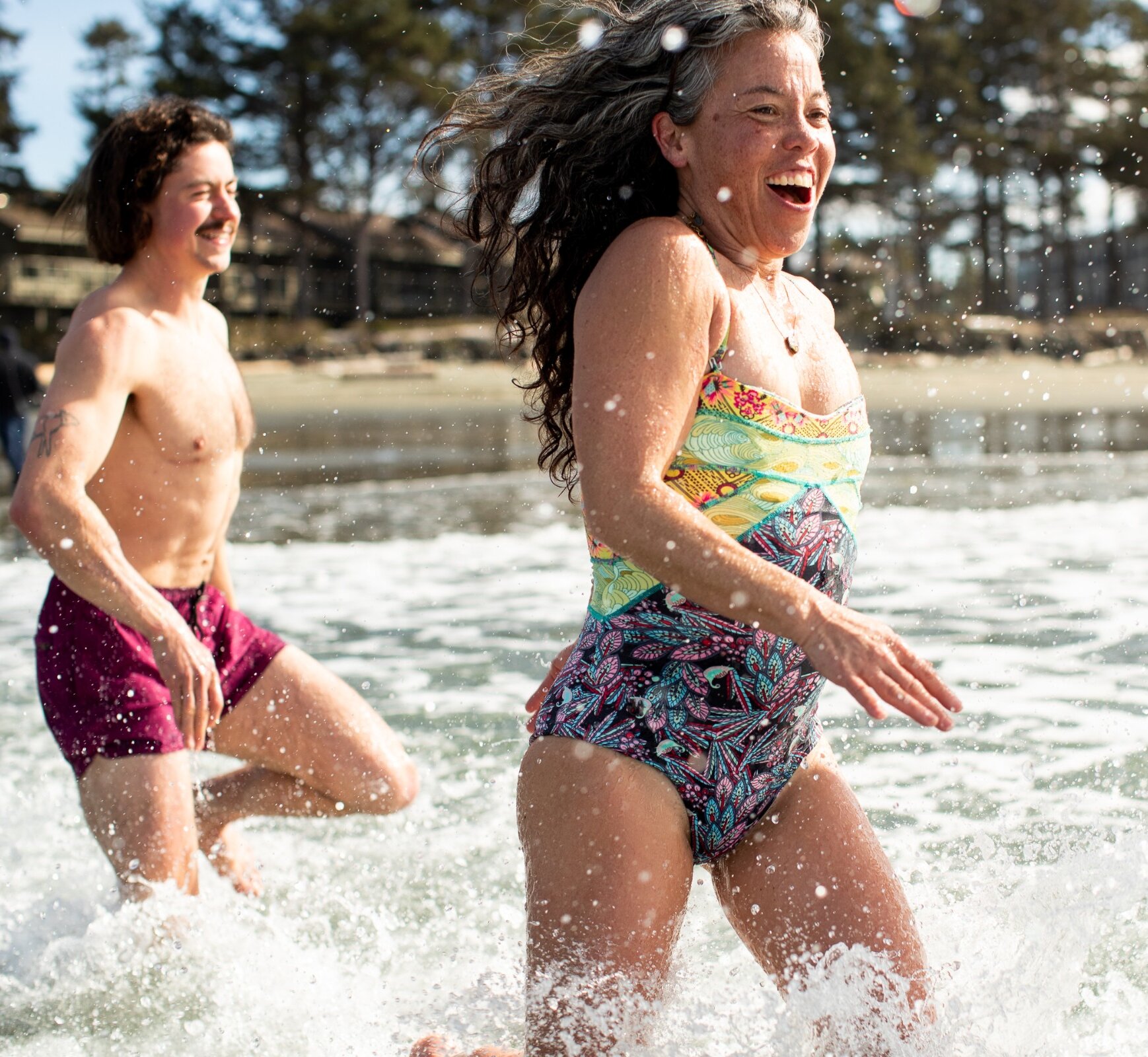 People running  from the sauna into the ocean waves