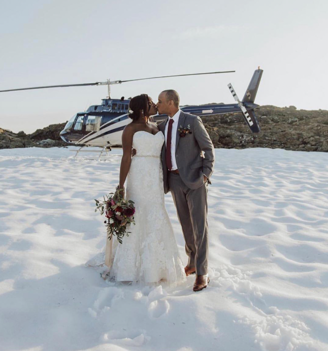 People getting married on a glacier with a helicopter in the background