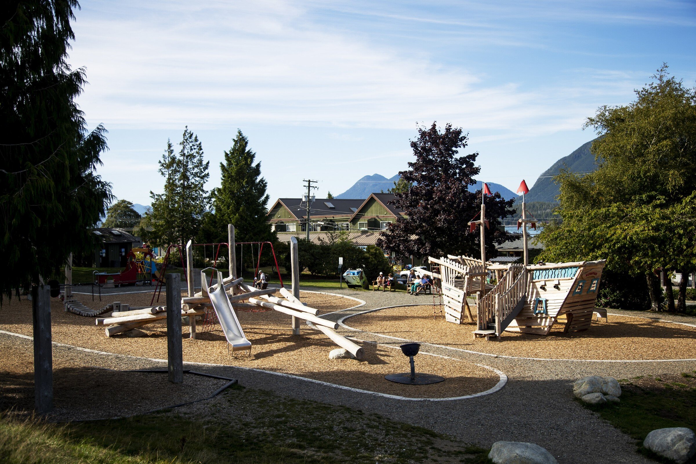 Playground for kids with a slide, swings and a wooden fort