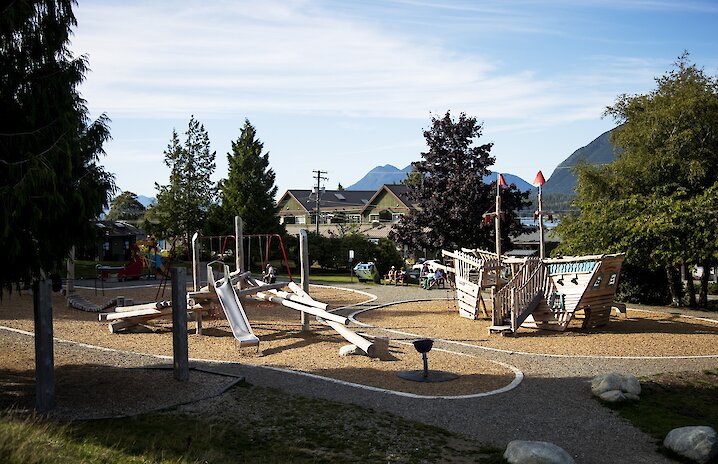 Playground for kids with a slide, swings and a wooden fort