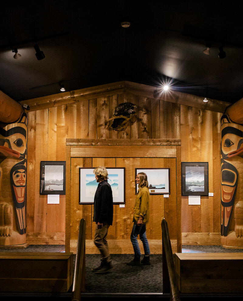 Visitors looking at the art and sculptures in the First Nations gallery