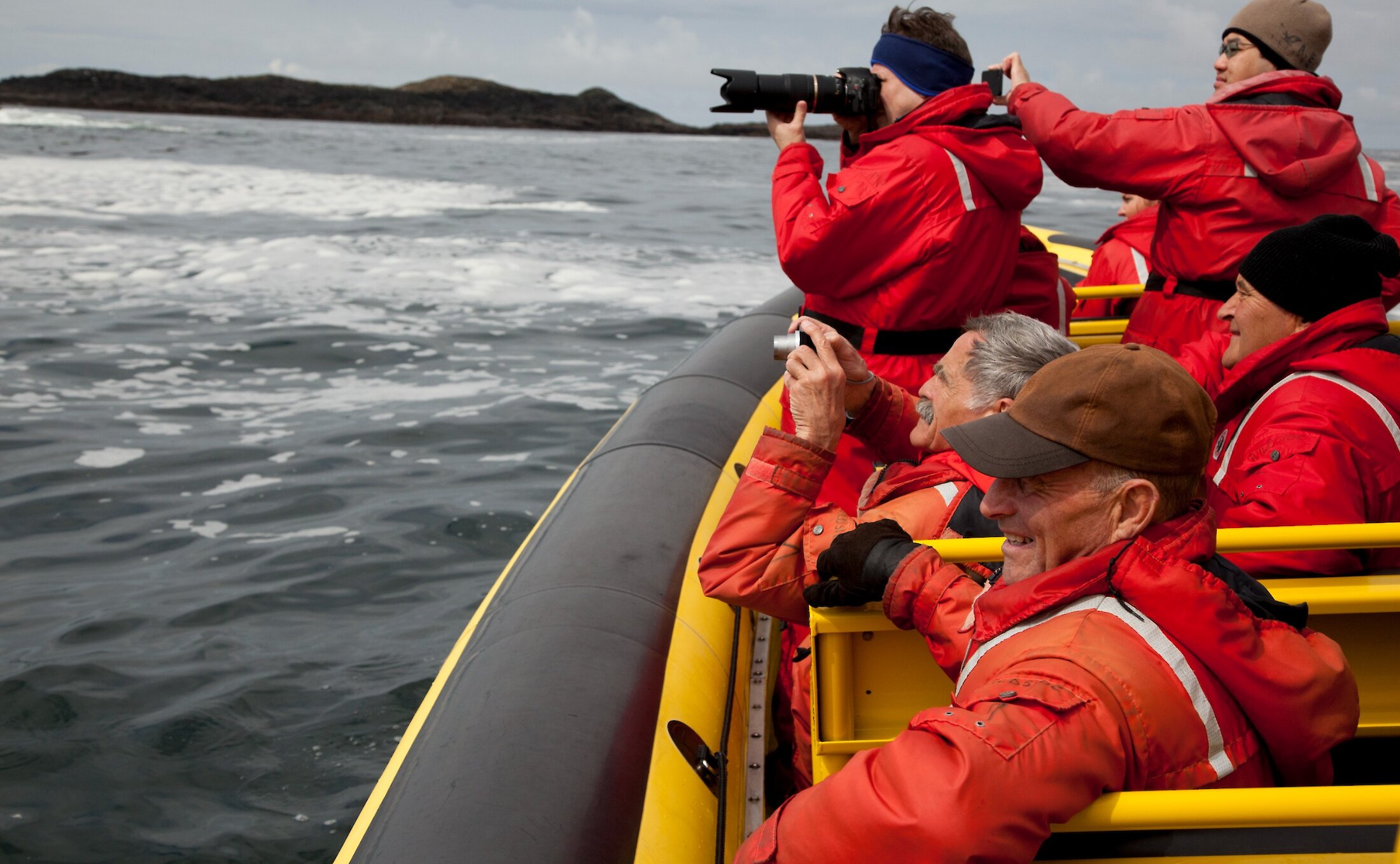 Group of people on a whale watching boat taking pictures