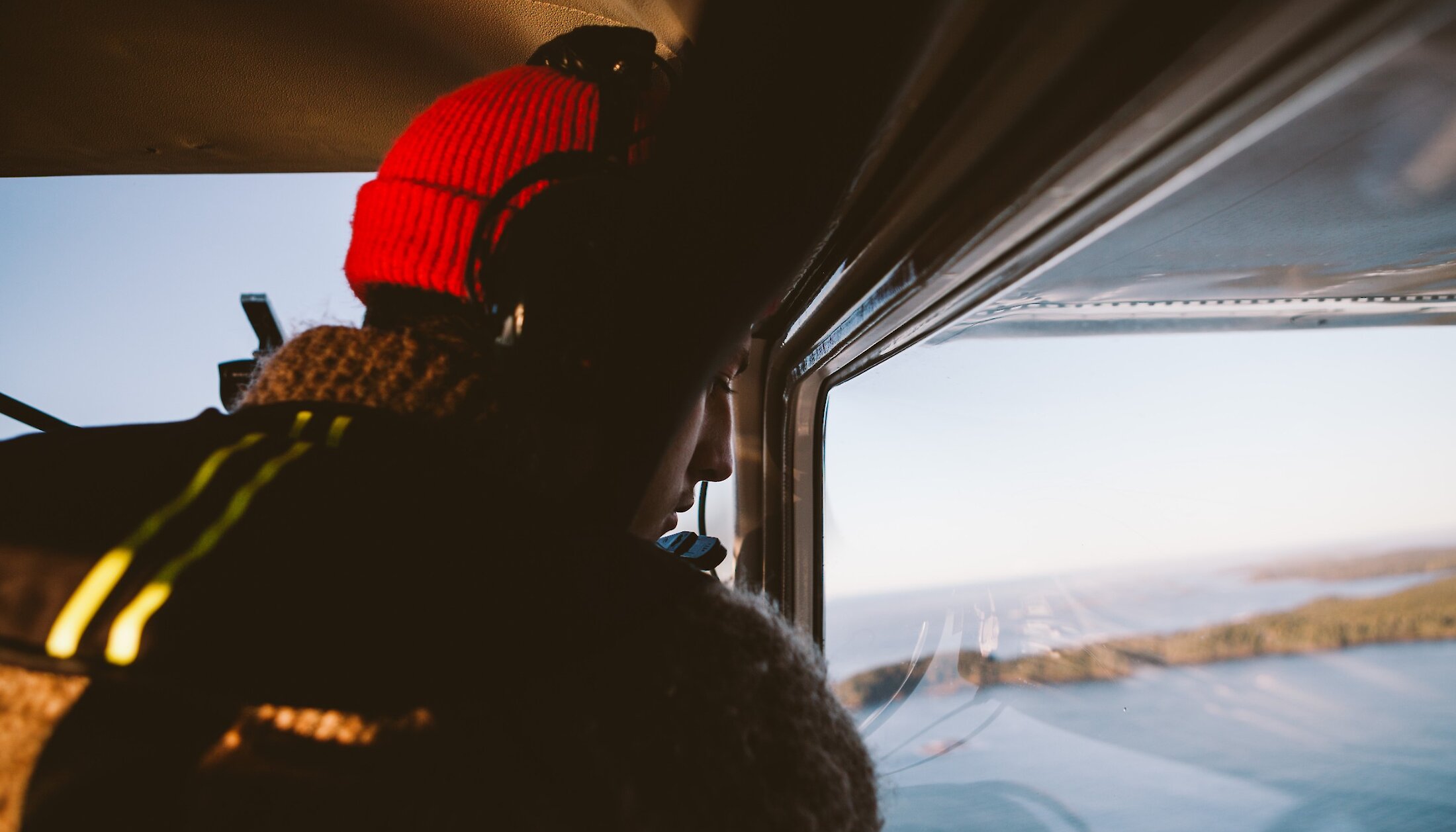 Person looking down from a float plane at the ocean below