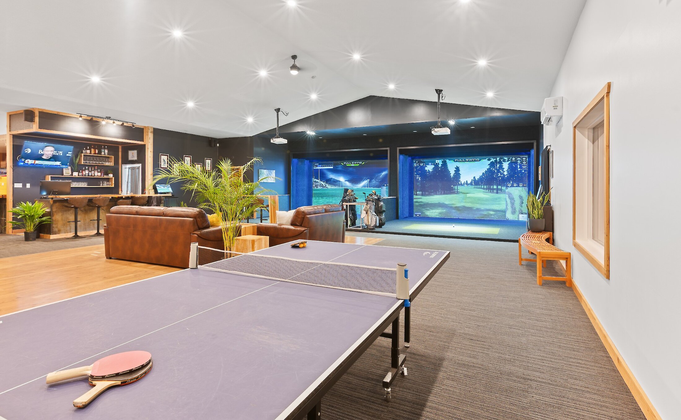 Indoor ping pong table and large room with golf simulators in the background in the Pro Shop at Long Beach Golf Course.