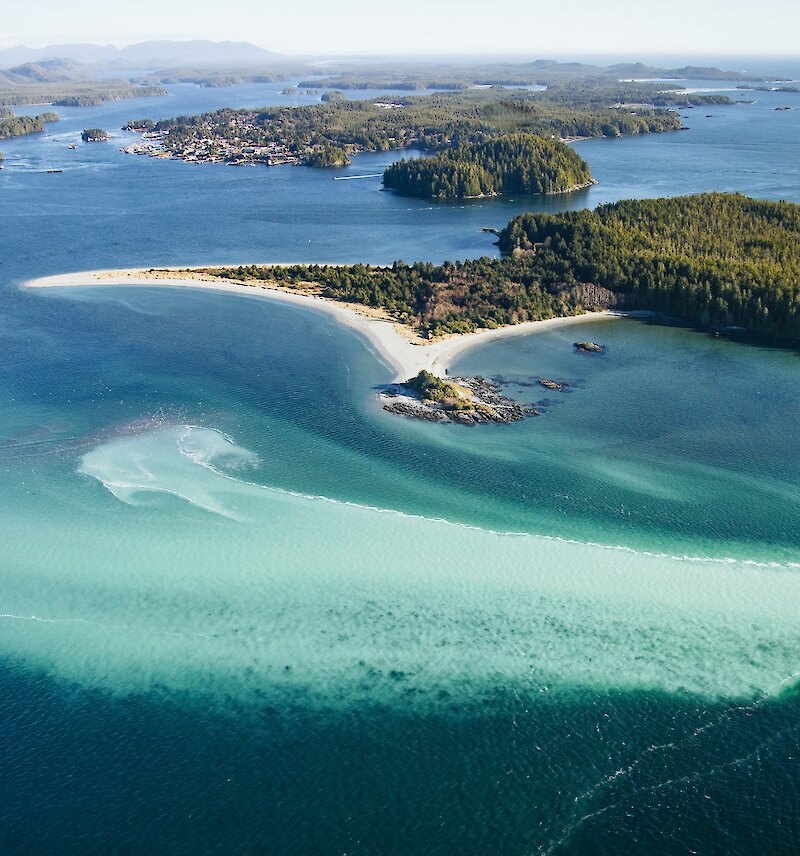 Aerial view of the ocean, Tofino, and islands with beautiful, tropical-looking turquoise waters from the herring spawn.